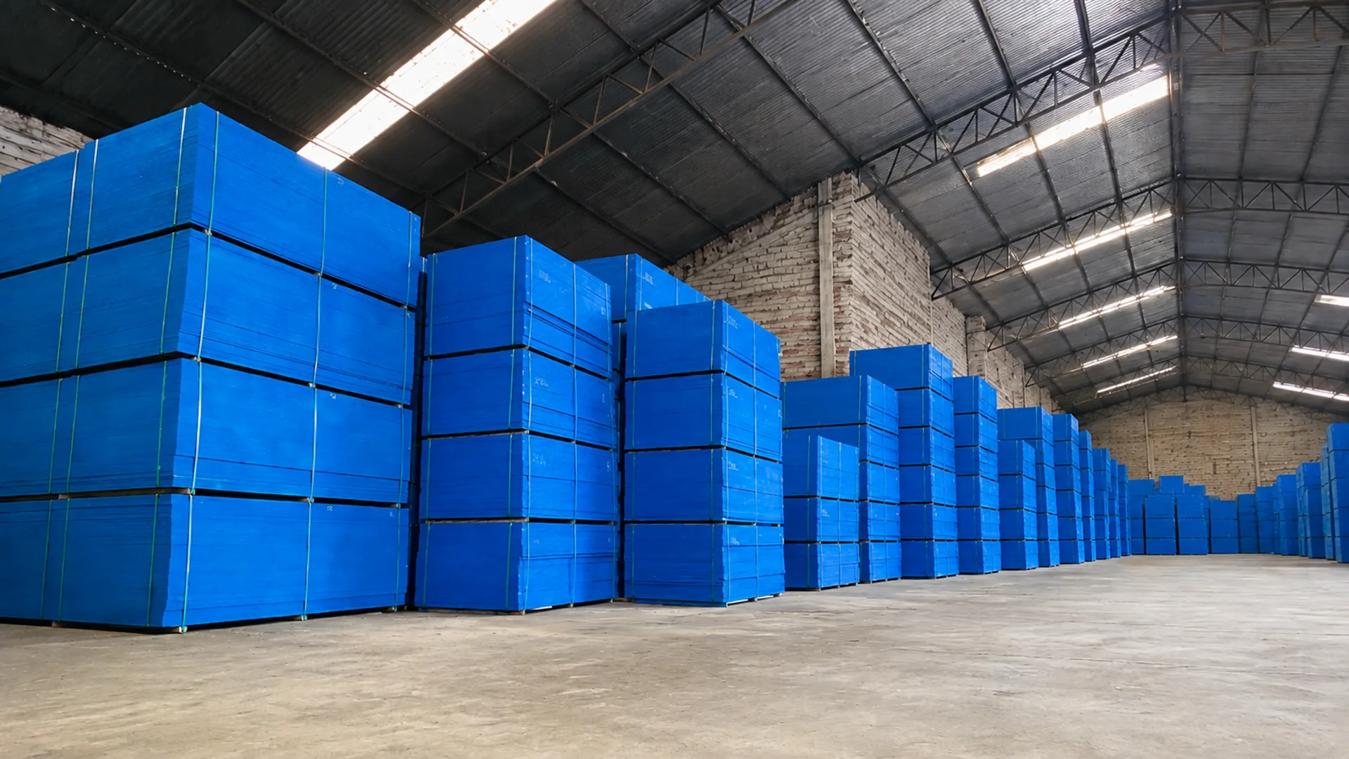 Compensados para construção civil | Baricomp Barigui Estoque de madeirite plastificado azul da Baricomp Barigui em barracão, para atendimento da construção civil em Curitiba.